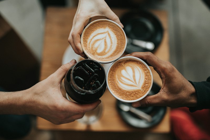Latte on a wooden table beside a notebook